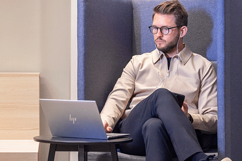 man sitter med laptop i en fåtölj