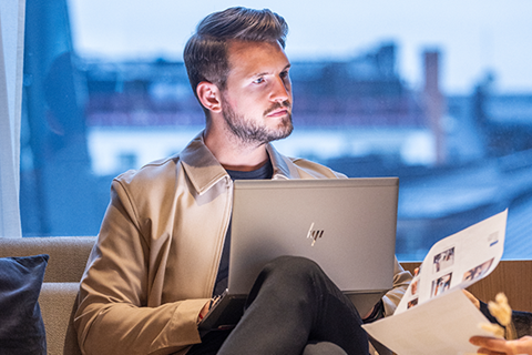 Man sitter framför laptop