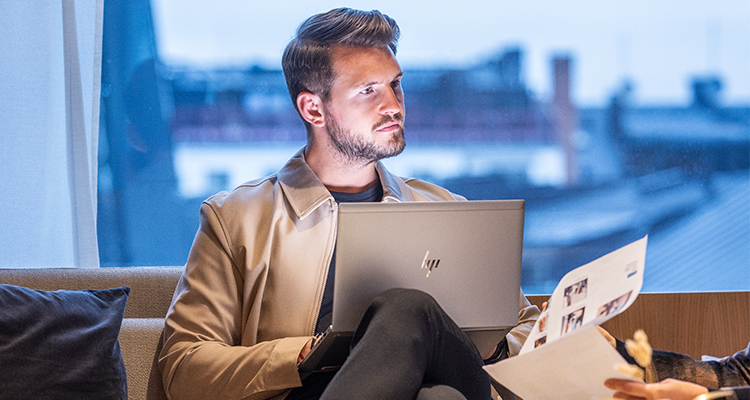 Man sitter framför laptop